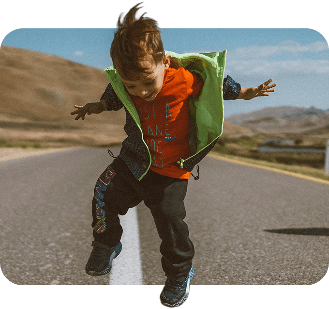 Child jumping on a road outdoors